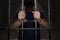 Arrested prisoner is holding bars in prison cell