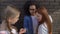 Arrogant female teenagers taking pupil smartphone, bullying in school backyard