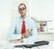 Arrogant man sitting at desk with glasses, a red tie and a blue