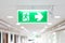 A Arrow light box sign of EMERGENCY FIRE EXIT is hung on the ceiling in hospital walkway, Idea for event fire or evacuation drills