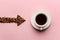 An arrow lined with coffee beans indicates a nearby cup of coffee.