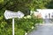 Arrow pointer with wedding text on green foliage background. The road leading to the wedding tent. outdoor celebration, field