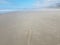 Arrow on sand at beach in Newport, Oregon with water