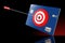 A arrow is stuck in the bullSeye of an archery target on a credit card