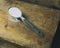 Arrowroot powder in a measuring spoon, spilled on a vintage cutting board. Room for copy.