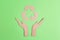 Arrows recycle eco symbol in cardboard hands silhouette on green background