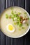 Arroz Caldo soup with rice, chicken and egg close-up. vertical t