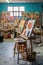 art classroom with easels, paints, and brushes