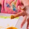 Art, creativity, beauty childhood concept. Close up young beautiful girl painting with colorful hands. Selective focus