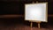 Art Easel with blank framed canvas in a darkened g