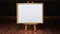 Art Easel with blank framed canvas in a darkened g