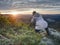 Art enthusiast with tripod on cliff. Peak with woman taking photos