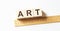 ART letters of wooden blocks in pillar form on white background, copy space