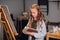 An art school student mixes colors on a palette for her canvas drawing in a workshop.