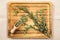 Artemisia vulgaris the common mugwort plant parts on wood spoon on natural color wood tray, indoors studio shot.