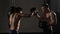 Artful young kickboxer fulfills blows with coach.