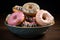 Artfully glazed ceramic pot holds a tempting assortment of delicious donuts
