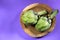 Artichoke close up. Fresh raw organic green Artichoke closeup. Over violet background. Healthy vegetarian food