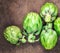 Artichoke flower buds. Fresh raw artichoke on wooden background close up