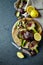 Artichokes and lemon halves on wooden chopping board. Flat lay