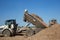 Articulated dump truck at work with a raised body at a construction site