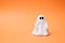 Artificial beautiful ghost on an orange background. Copy space for text. Festive concept