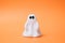 Artificial beautiful ghost on an orange background. Copy space for text. Festive concept