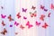 The artificial colorful butterflies on colorful curtain background. The butterflies fly one by one in a curve.