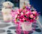 Artificial flower in vase with blurry doll in the