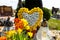 Artificial flowers in the shape of a heart and candlesticks lie on the tombstone in the cemetery.
