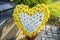 Artificial flowers in the shape of a heart lie next to the tombstone in the cemetery.