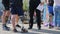 Artificial foot of handicapped man in comfortable shoes standing next to healthy people on asphalt road in city