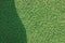 Artificial grass fake turf synthetic lawn field macro closeup, gentle shaded shadow area, green sports astroturf texture,