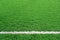 Artificial grass of football field with white stripe, Soccer corner line detail, Green astro turf for texture background