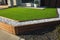 Artificial grass lawn turf with wooden edging in the front yard of a modern Australian home.