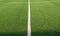 Artificial green grass and white border lines. Artificial turf for soccer field. Football field in an outdoor stadium