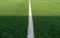 Artificial green grass and white border lines. Artificial turf for soccer field. Football field in an outdoor stadium