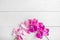 Artificial orchids on white wooden background