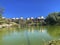 An artificial pond in Parque de la Paloma, an urban park in BenalmÃ¡dena, Spain. A few apartment buildings in the back