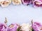 Artificial purple rose flowers on linen copy space border background