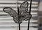 Artificial silver butterfly made of wire and transparent beads on a background of white blinds