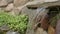 An artificial waterfall created by human hands. Water flows down the stones into the pond, landscaping. Background for