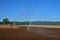 Artificial watering of a field due to dryness. A rainbow parallel to the water jet