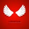 Artificial white paper wings on red background.