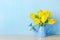 Artificial yellow tulip flowers at blue watering can