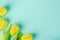 Artificial yellow tulip flowers bouquet on light green blue background