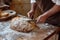 artisan baker scoring sourdough with a lame on a wooden countertop