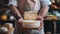 Artisan cheese maker holding matured wheels of cheese