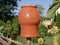 An artisan clay vessel for liquid dries on a makeshift fence made of long branches on a hot summer day in the village.