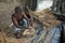 An artisan preparing structures with clay and bamboo sticks.